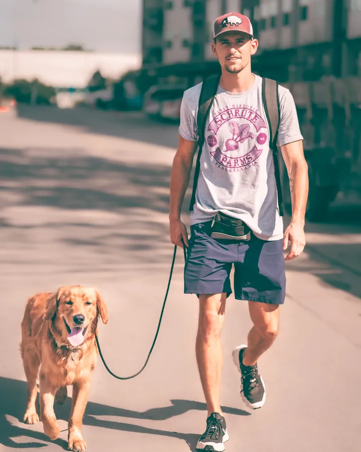 Clayton Mathews, owner and head trainer at Austin Dog Culture, walking a golden retriever on a loose leash